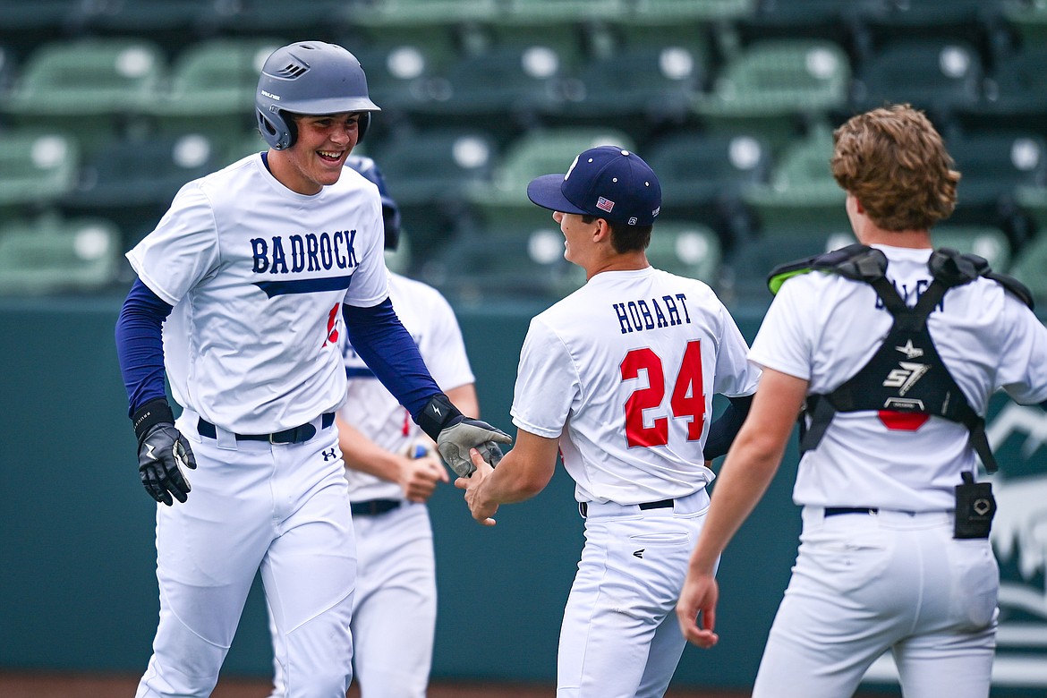 Badrock's Logan Stewart (13) gets congratulated by teammates after his first of two inside-the-park home runs against Libby during the Badrock Invitational at Glacier Bank Park on Thursday, June 27. (Casey Kreider/Daily Inter Lake)