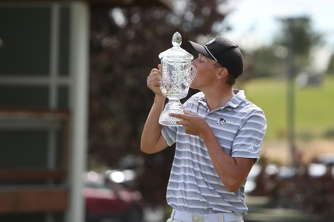 Dane Huddleston, Woodland, kisses the trophy after winning the WA Golf Men’s Amateur Championship Thursday in Moses Lake.