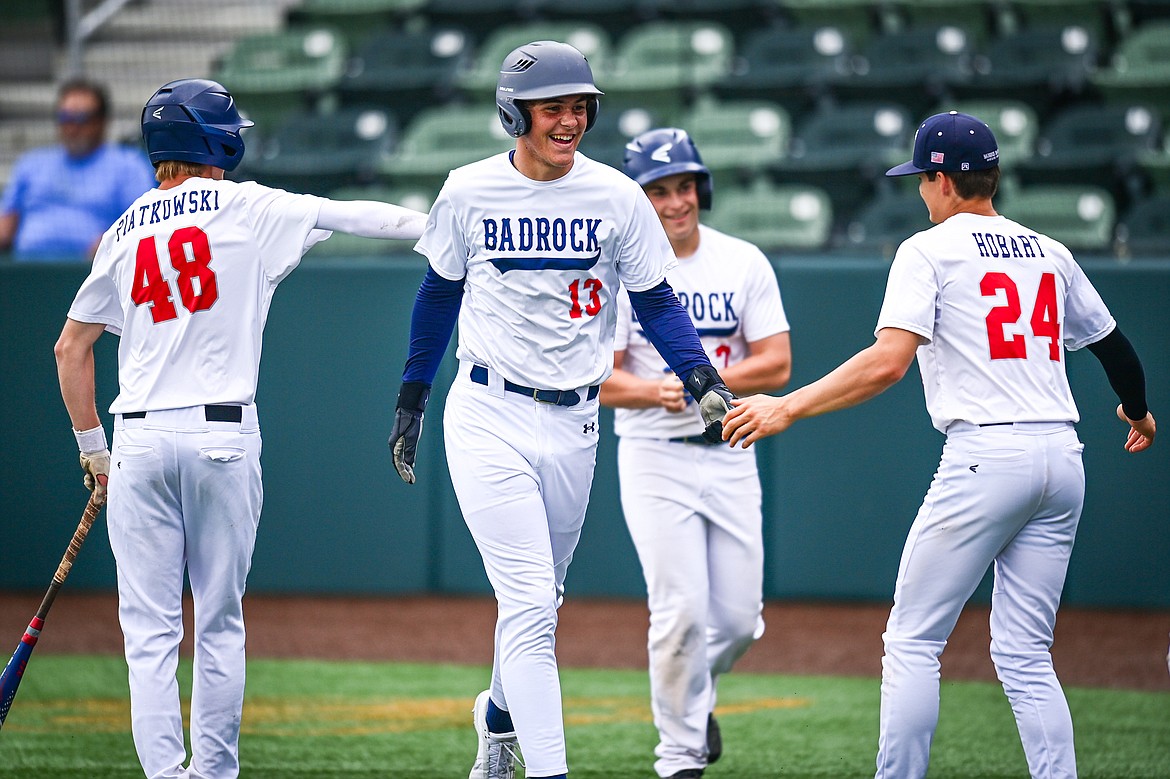 Badrock's Logan Stewart (13) gets congratulated by teammates after his first of two inside-the-park home runs against Libby during the Badrock Invitational at Glacier Bank Park on Thursday, June 27. (Casey Kreider/Daily Inter Lake)