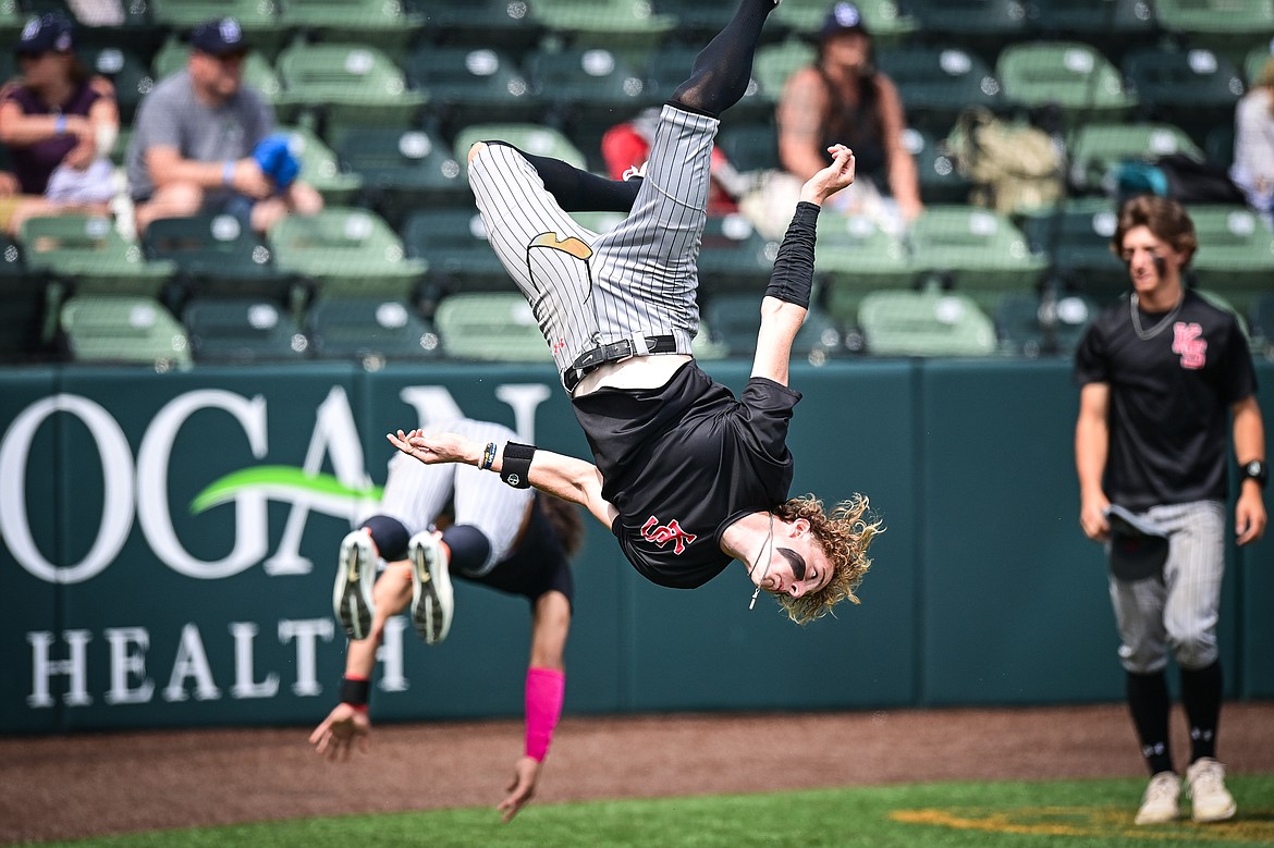 Kalispell Sluggers' Cooper Pelc (8), Jordan Griffin (0) and other teammates perform roundoffs and backflips after an 11-7 win over Badrock in the semifinals of the Badrock Invitational at Glacier Bank Park on Saturday, June 29. (Casey Kreider/Daily Inter Lake)