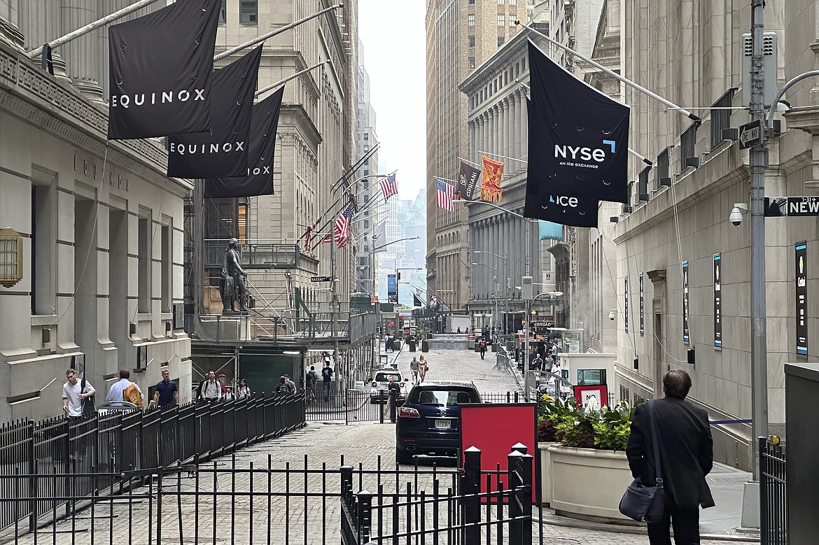 A man walking on Wall Street approaches the New York Stock Exchange, right, on June 26, 2024, in New York. Shares advanced in Europe on July 1, 2024, with the benchmark in Paris up 2.8% briefly after the far-right National Rally gained a strong lead in first-round legislative elections. (AP Photo/Peter Morgan, File)