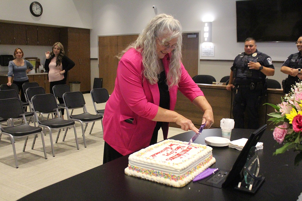 Nancy Schanze cuts her retirement cake on her last day of work June 28.