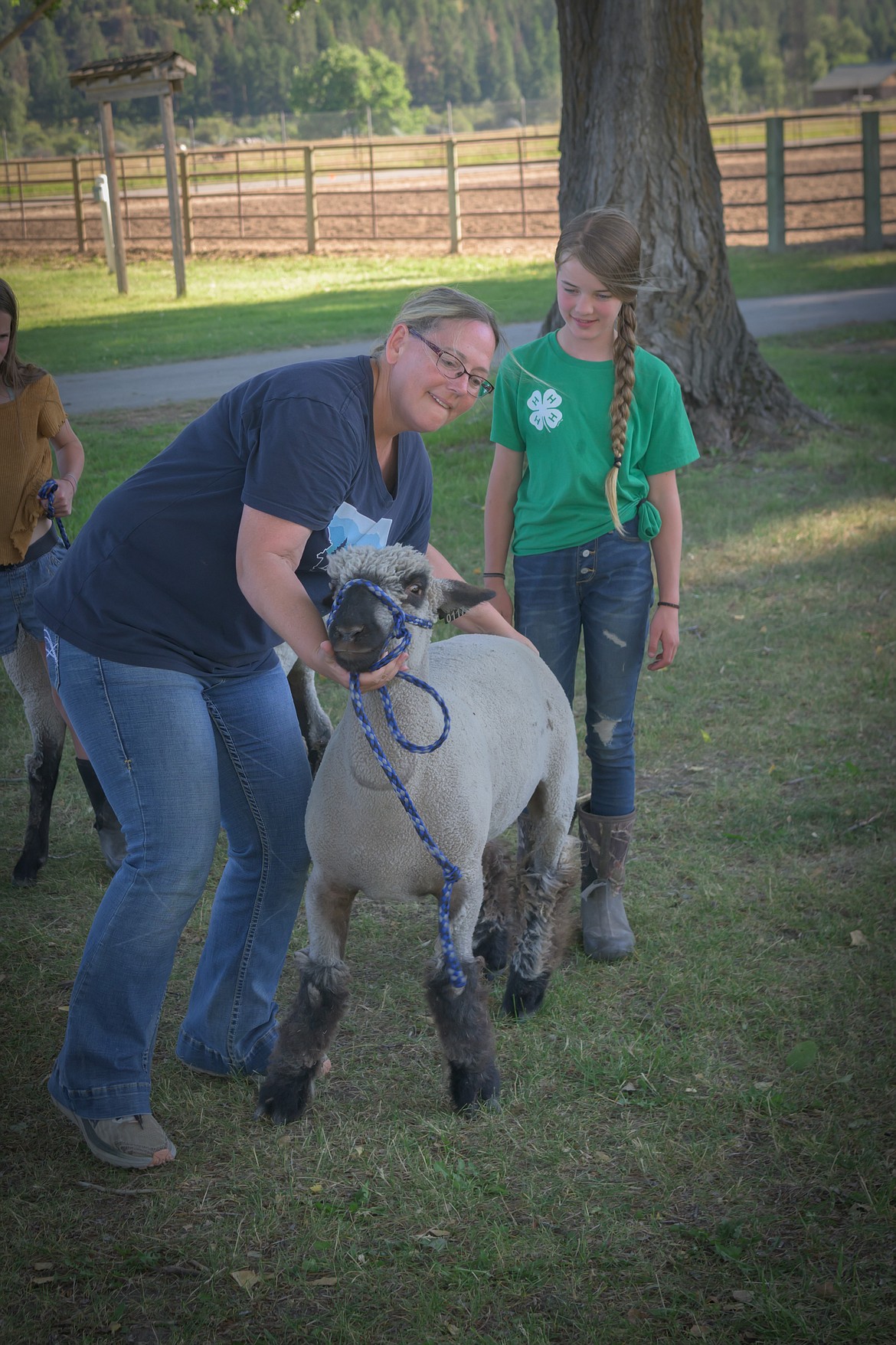 4-H project leader Juli Thurston shows Moriah Champneys animal handling techniques. (Tracy Scott/Valley Press)