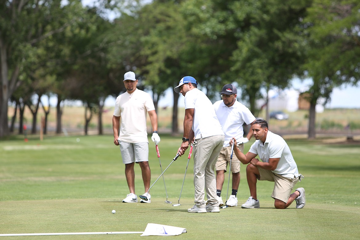 A team of golfers watches as one putts on the 10th green at the Sage Hills Golf Club in Warden. The Please Hit Straight golf tournament, raising money for the Warden High School wrestling program, had 29 teams sign up this year – the most in the tournament’s three-year history.