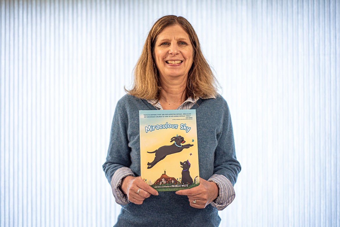 Michelle Weltz with her book “Miraculous Sky.” (Avery Howe/Bigfork Eagle)