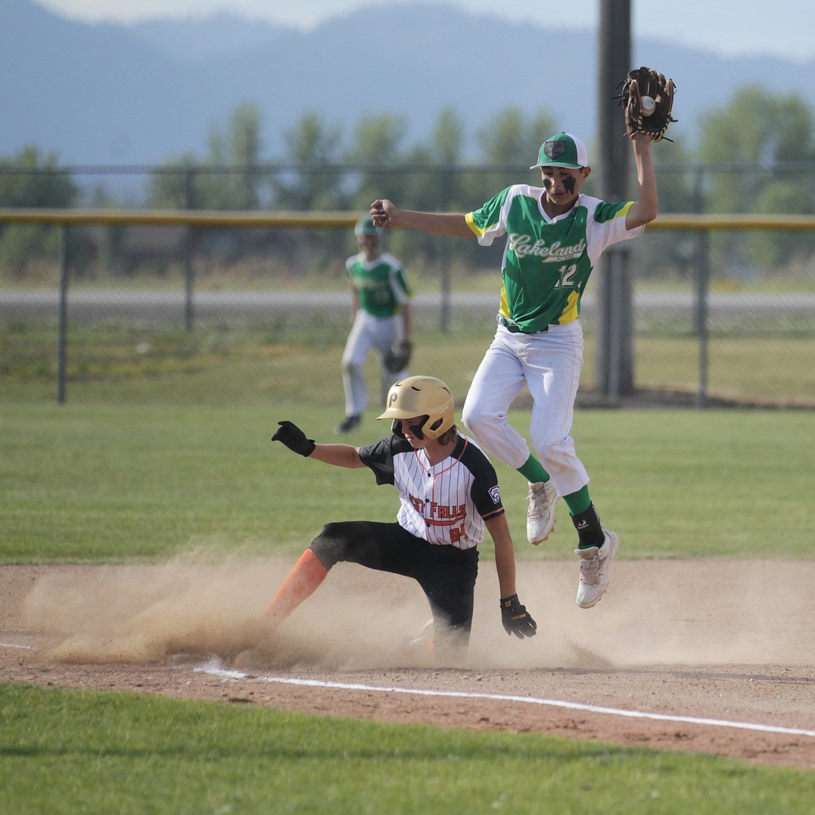 MARK NELKE/Press
Gavin Ahlgren (84) of Post Falls slides safely into third base as Lakeland third baseman Hunter Cailteaux snags the throw during the Little League Juniors District 1 championship game Tuesday at Croffoot Park in Hayden.