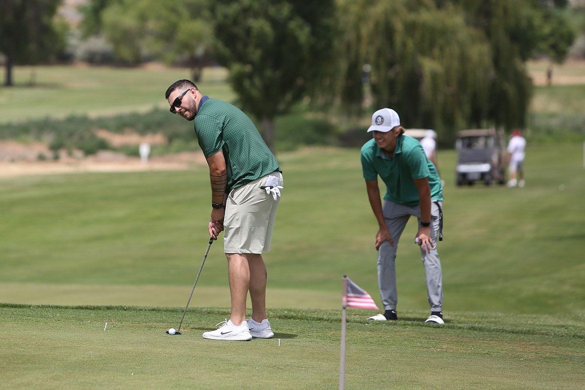 A golfer swings his putter in the putting competition at Saturday’s Please Hit Straight golf tournament in Warden.