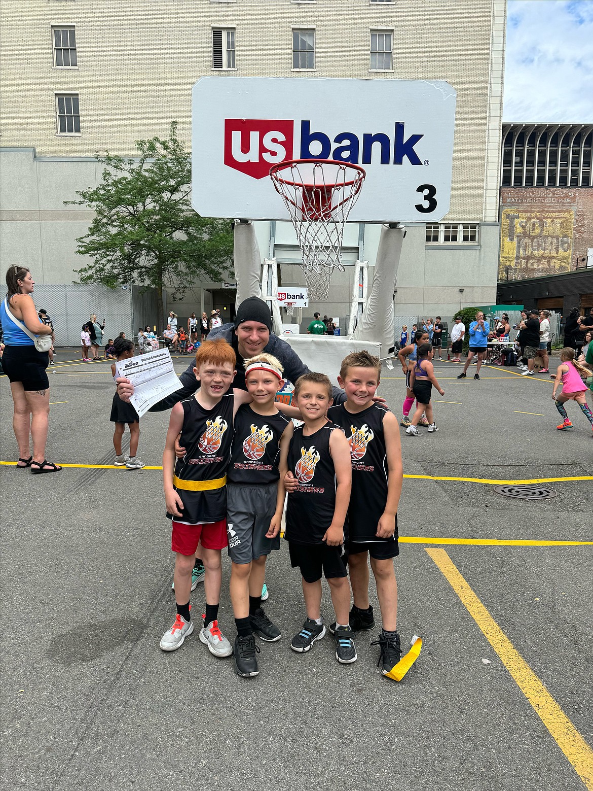 From left, Riggs Lightbody, Abishai Bever, Grady Rowland and Bronson Blanford of the Sandpoint Swishers are all smiles with coach Nate Bever after going 4-0 to win their Hoopfest bracket this past weekend. All four players will be heading into second grade this upcoming school year at Washington Elementary.