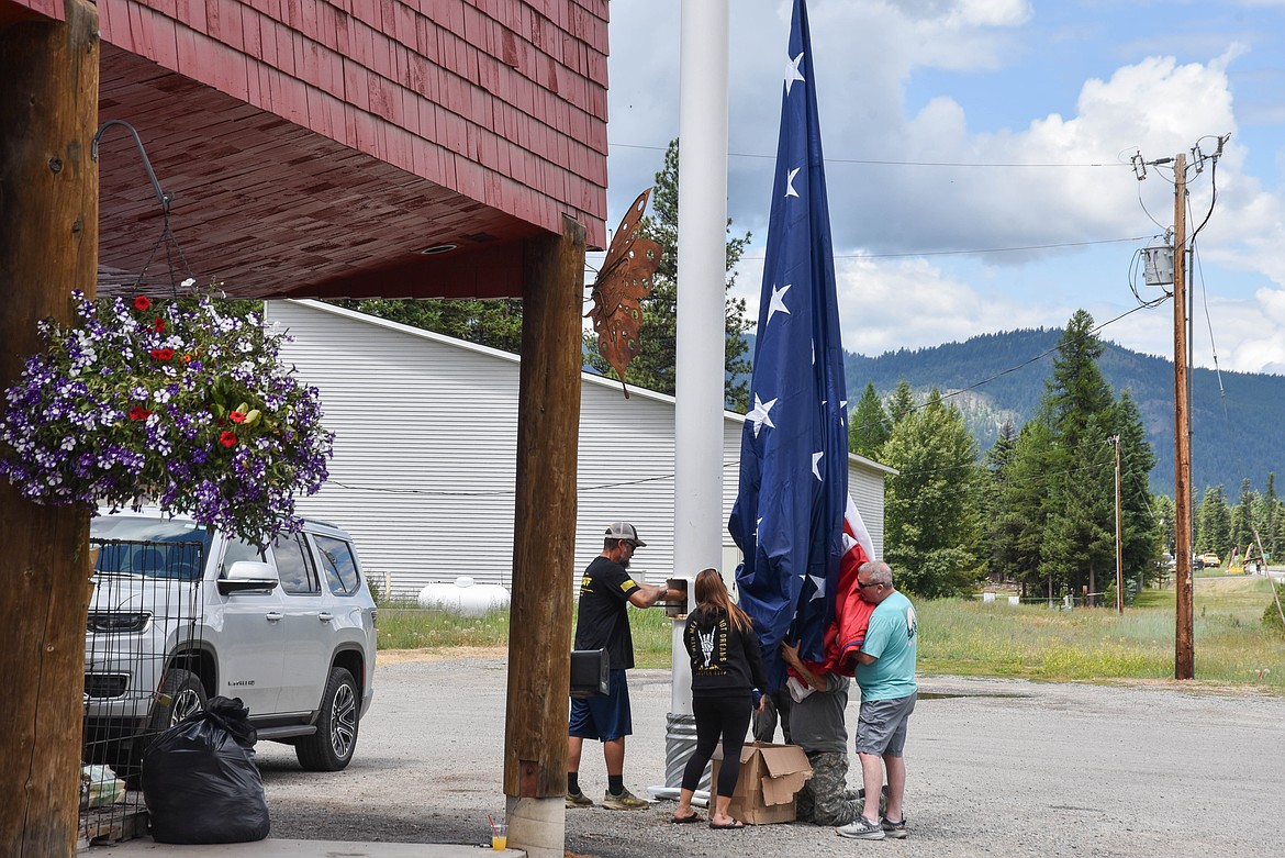 Patrons switch the flag at Happy's Inn, between Libby and Kalispell, which has one of the biggest American flags in the state. (Kate Heston/Daily Inter Lake)