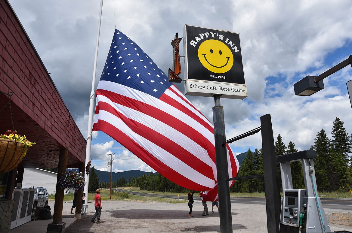 Patrons switch the flag at Happy's Inn, between Libby and Kalispell, which has one of the biggest flags in the state. (Kate Heston/Daily Inter Lake)