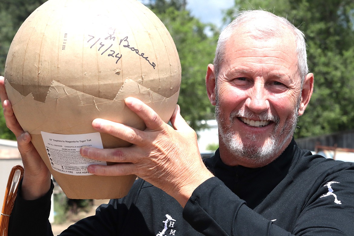 Craig Brosenne, president of the Hagadone Marine Group, holds up one of the 12-inch shells at Murphy Marine on Wednesday that will be part of tonight's fireworks show over Lake Coeur d'Alene.