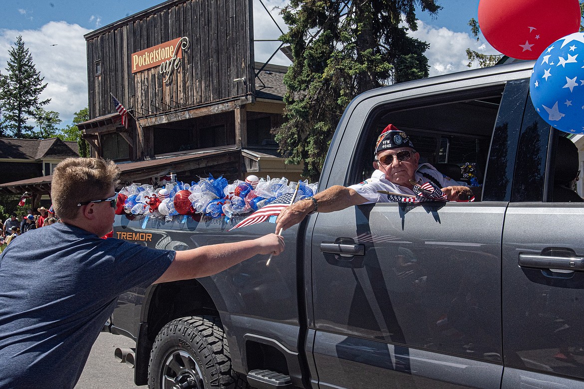 Members of the Bigfork VFW hand out American flags at the Fourth of July parade Thursday. (Avery Howe/Bigfork Eagle)