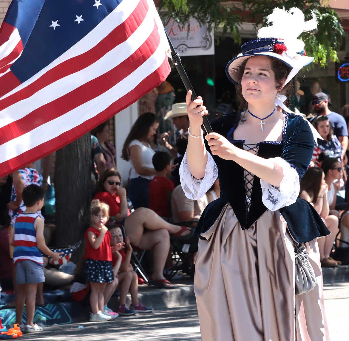 Katie Preston with the Daughters of the American Revolution carries a flag in the parade.