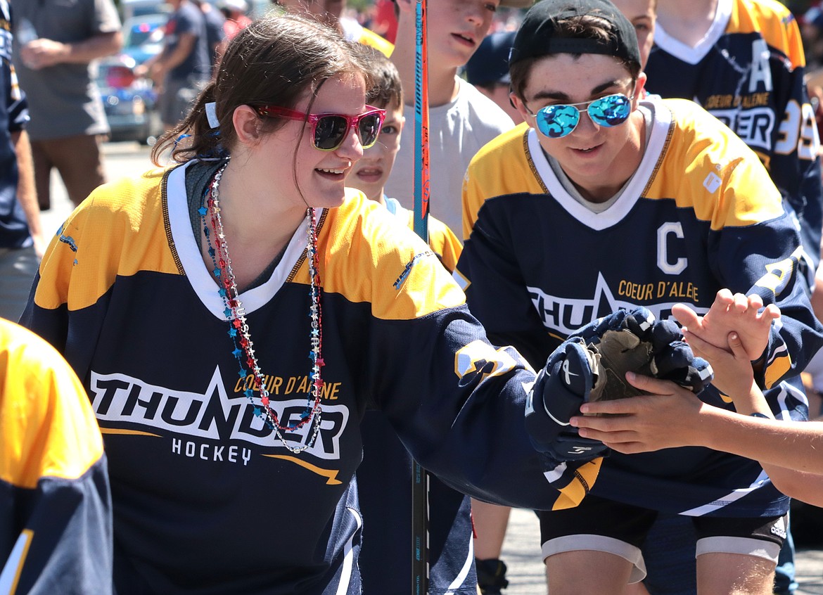 Samantha Taub with the Coeur d'Alene Ladies Thunder hockey team high fives spectators at the Fourth of July parade in Coeur d'Alene.