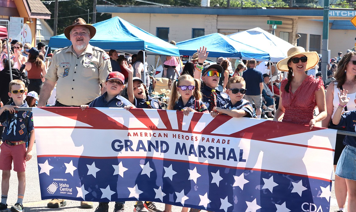 Cub Scout Pack 215 members carry a banner in the parade.