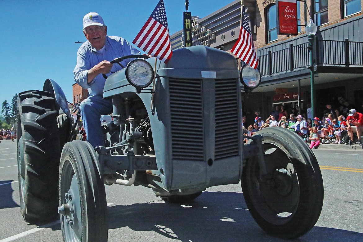 Dover Mayor George Eskridge drives an antique tractor down First Avenue during the Sandpoint Lions Fourth of July Grand Parade.