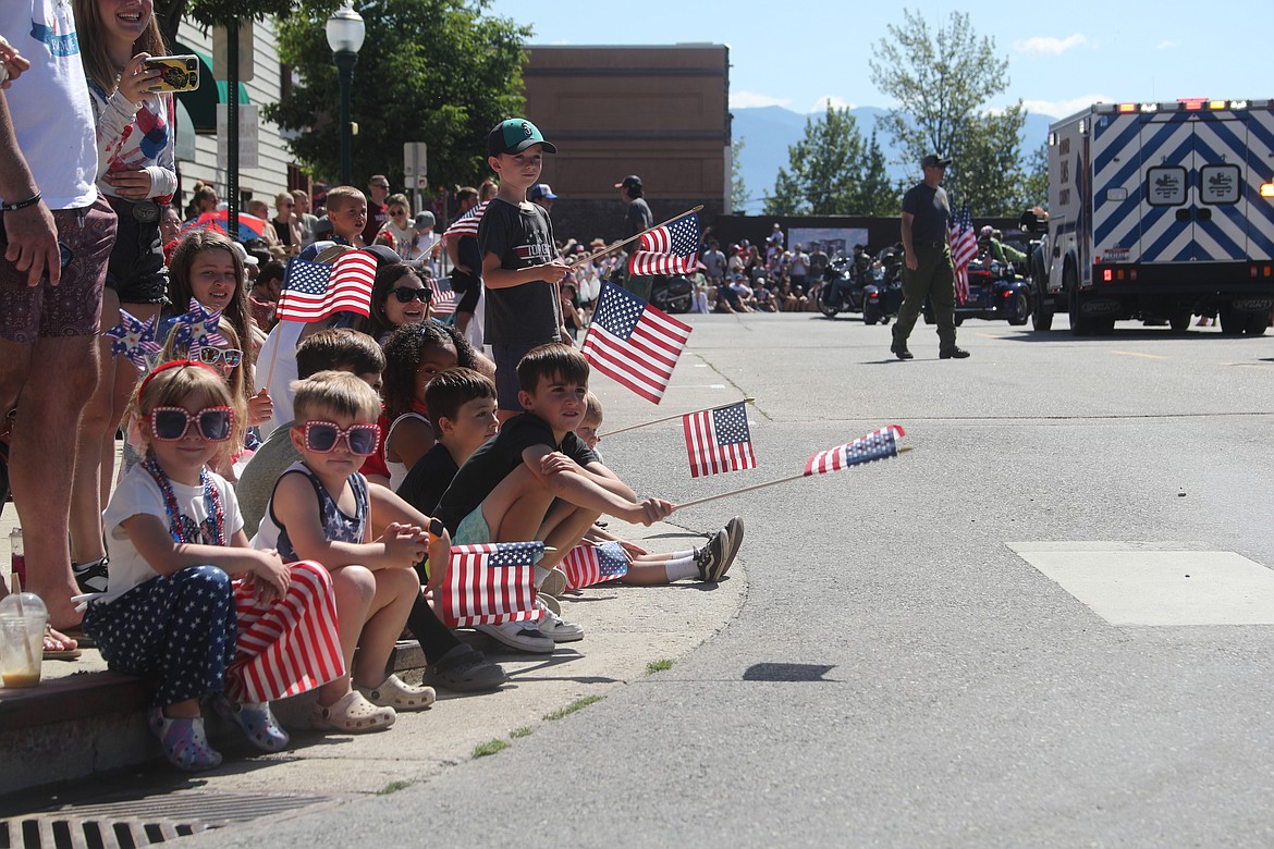 Area youngsters wave American flags as they watch floats make their way down Church Street during the Sandpoint Lions' Grand Parade on the Fourth of July.