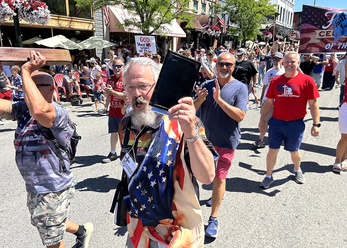 Pastor Tim Remington holds a Bible during the Fourth of July parade.