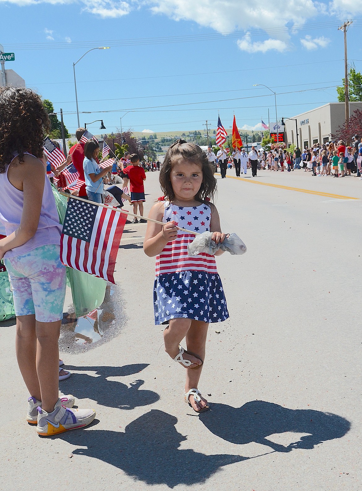 POISED FOR PARADE – This petite Polson parade-goer was well prepared with a flag in one hand a candy bag in the other. (Kristi Niemeyer/Leader)