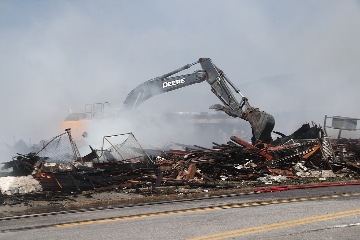 Fire crews work to get to hot spots at the Army Surplus building after the business was gutted in a July 4 fire.