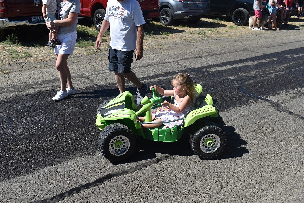 Four-year-old Blakely Van Dyke drives an electric car in the Fourth of July parade in George Thursday morning.