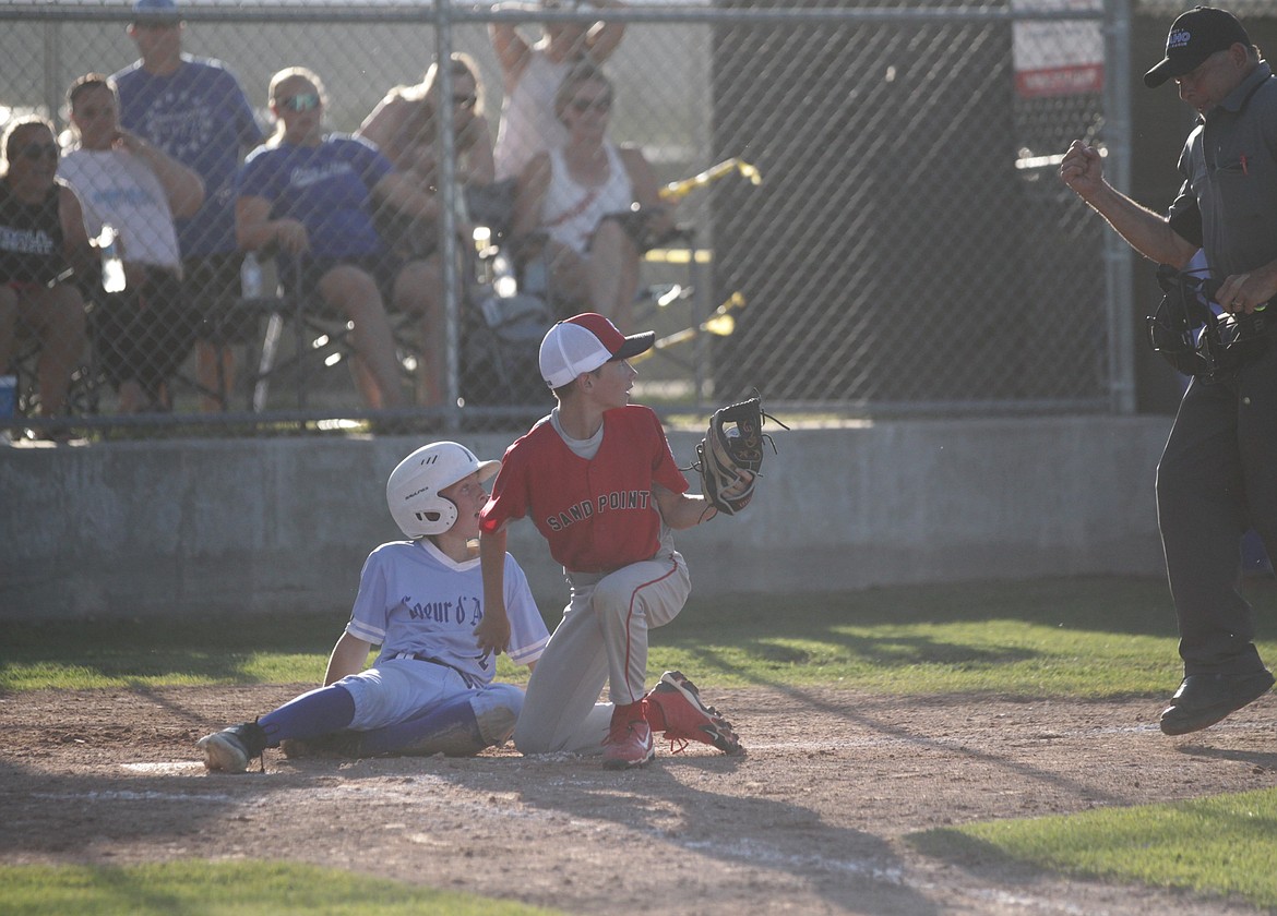 Kellan Larson, left, of Coeur d'Alene and Eli Franz of Sandpoint look to the umpire for the call as Larson tried to score in a Little League (12U) District 1 tournament game Saturday at Croffoot Park in Hayden.