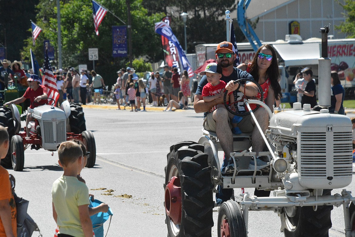 Wade and Ashley Bache, with little Hudson maneuver one of the fan-favorite vintage tractors on the 4th of July. (Amy Quinlivan/Mineral Independent)