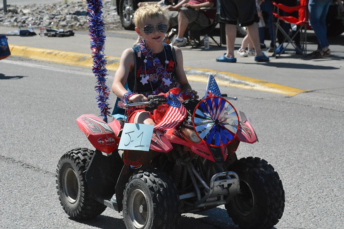 Dominic Mancini drives his patriotic four-wheeler down Old Highway 10 in St. Regis during the Independence Day parade on Thursday. (Amy Quinlivan/Mineral Independent)