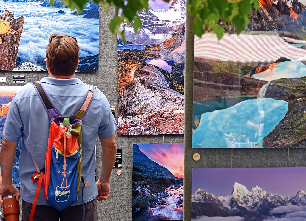 A visitor takes in high altitude photography by Colorado based Jason Weiss. (Kelsey Evans/Whitefish Pilot)