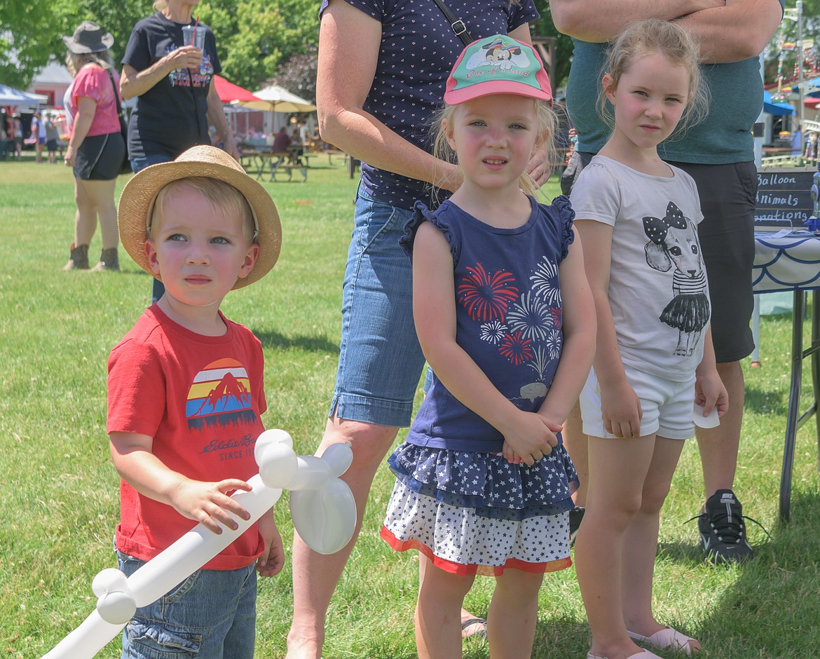 Berrio family children from left, 2-year-0ld James, 4-year-old Emilia and 6-year-old Sophia wait for their turn with Trout Creek Clown Skeeter. (Tracy Scott/Valley Press)