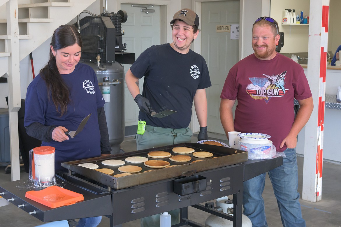 Cooks Una Stowers, Braeen Starika and Tim Kinsinger at the Plains-Paradise Rural Fire District pancake breakfast. (Tracy Scott/Valley Press)