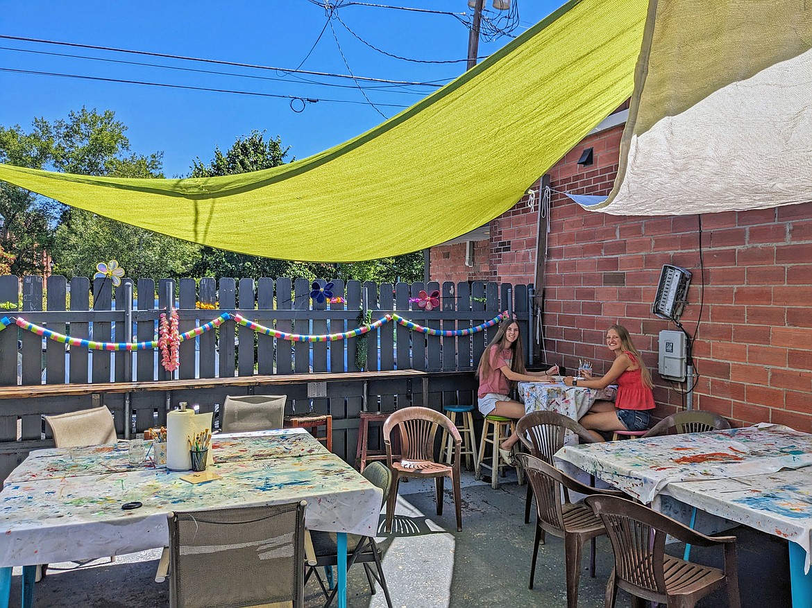 On a busy summer Saturday, Jodran Bauer and Abby Persinger of Kalispell are the only visitors to take to the back patio of Stumptown Art Studio. Pictured is part of the space that would be utilized for the new classroom building. (Kelsey Evans/Whitefish Pilot)