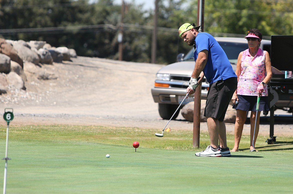 A golfer swings in the closest to the pin competition at the Othello Wrestling Club golf tournament in Othello.