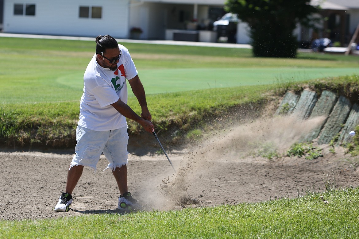 A golfer swings their way out of a sand trap at the Othello Wrestling Club tournament at the Othello Golf Club.