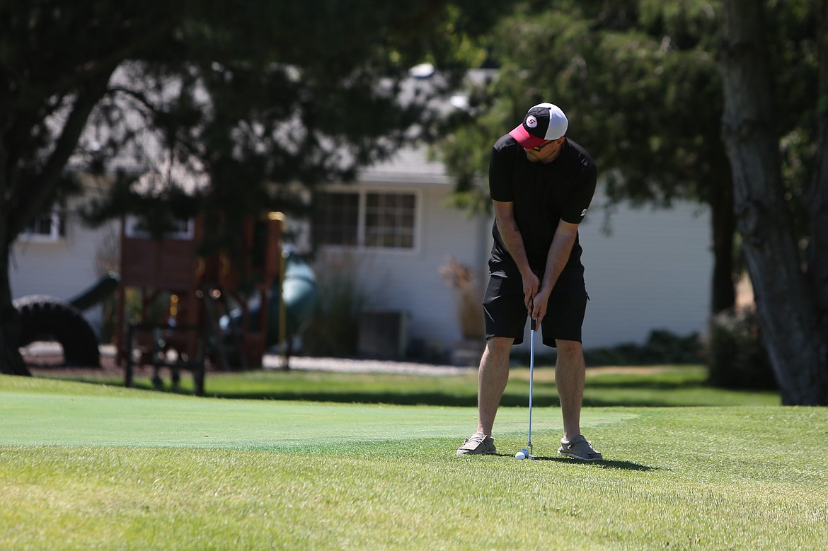 A golfer lines up a shot just outside the ninth green at Saturday’s Othello Wrestling Club golf tournament.