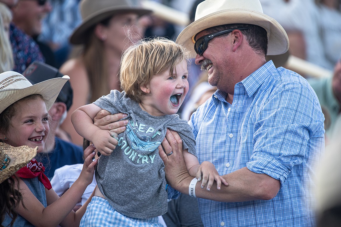 A young rodeo-goer gets hoisted above the crowd. (Avery Howe/Bigfork Eagle photo)