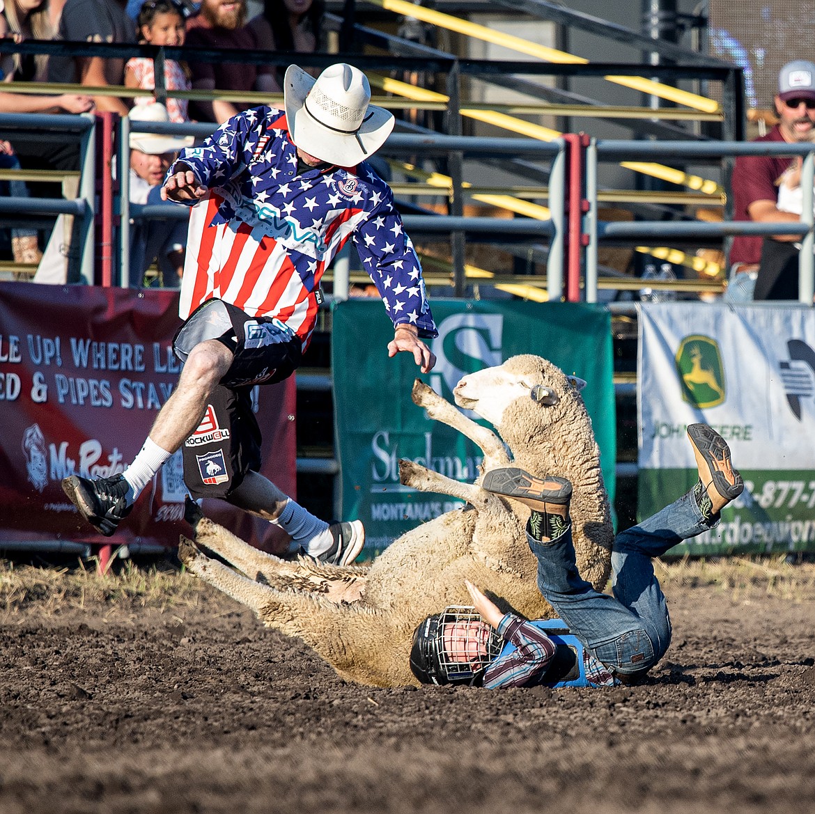 A mutton-buster and their sheep take a tumble on Friday. (Avery Howe/Bigfork Eagle)