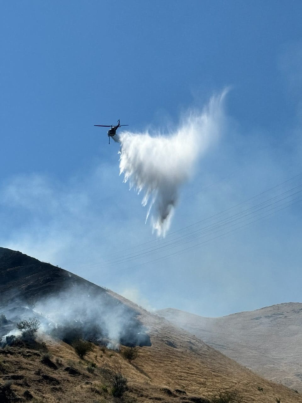 A helicopter drops a load of water on the Red Wolf Fire along the Snake River near Clarkston.