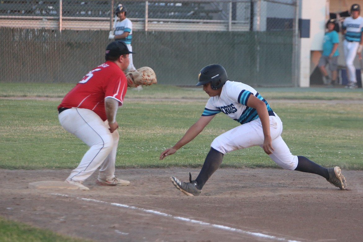 River Dog first baseman Andre Godefroy, right, turns back to first base to avoid being picked off in the bottom of the first inning against Othello on Tuesday.