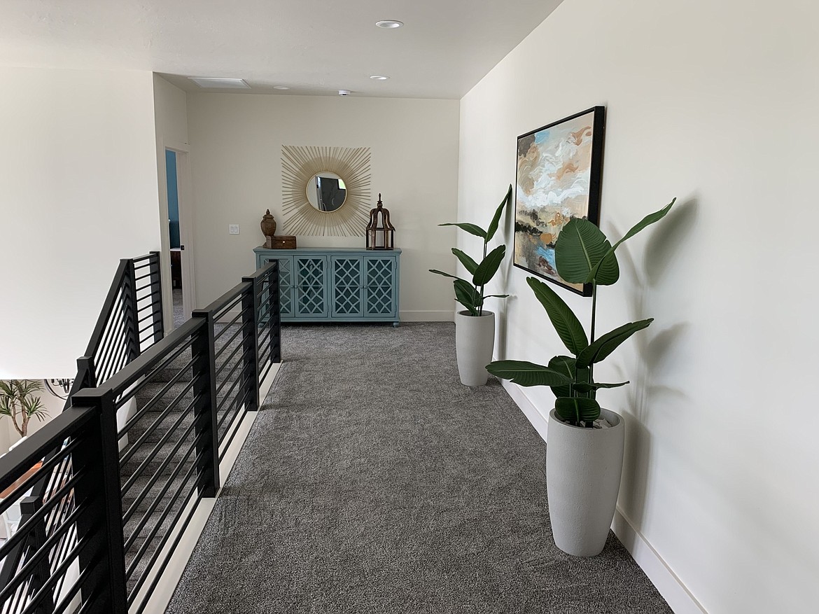 Hallways don’t have to be boring. Adding a few select pieces of art and a bit of storage can add functionality and make the home more inviting as a whole.