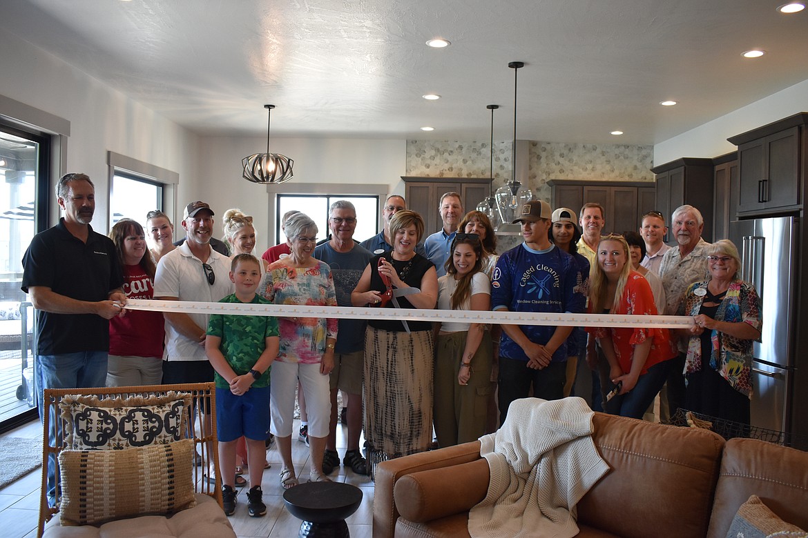 DeeDee Clune cuts the ribbon as part of her joining the Moses Lake Chamber of Commerce. The ceremony was held in a home she’d recently staged for a client to sell.