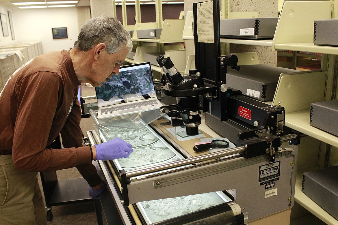 Volunteer John Pierce compares original images to Google Earth using a light table to identify the coordinates for the centerpoint of each historical image. (Photo courtesy UM News Service)