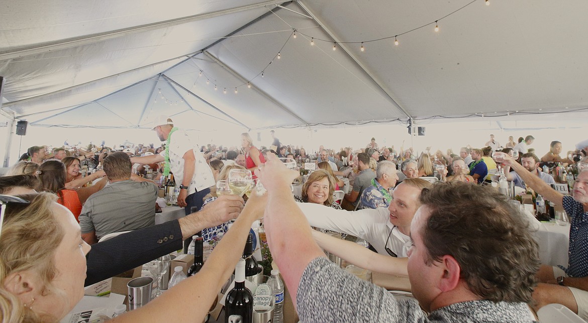 Attendees toast Thursday evening to a $1 million donation and the announcement of a new name at the Children's Village Annual Event. Children's Village will soon transition to Canopy Village.