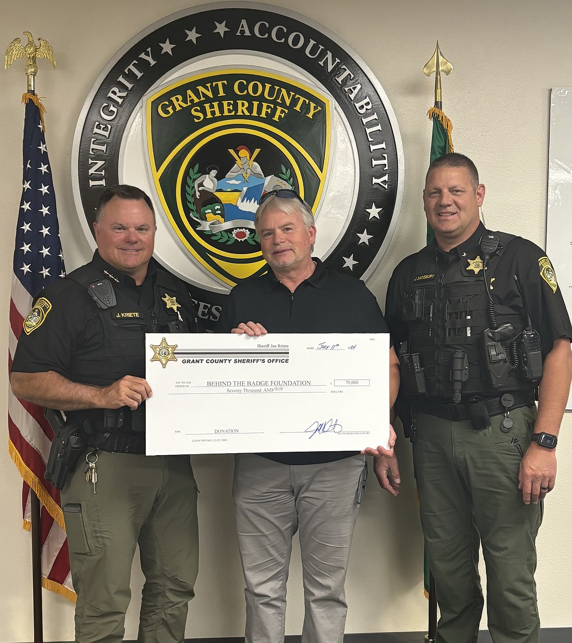 Grant County Sheriff Joey Kriete, left, and GCSO Chief Deputy Josh Sainsbury present Behind the Badge Foundation Executive Director Brian Johnston with a $70,000 check. The donation was raised at the 8th Annual John Bernard Memorial Golf Tournament, held at Moses Lake Golf Club on May 8, according to an announcement by the GCSO.