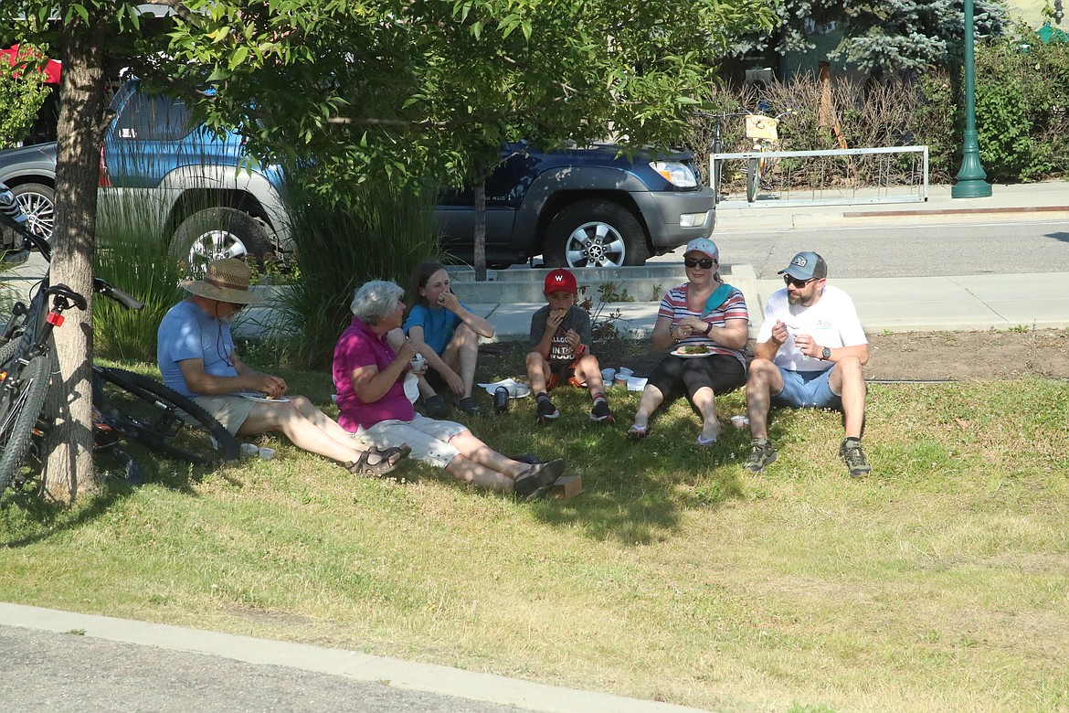 A group finds a spot of shade to enjoy a healthy dinner offered to community members at Bonner General Health's 75th anniversary celebration Friday.