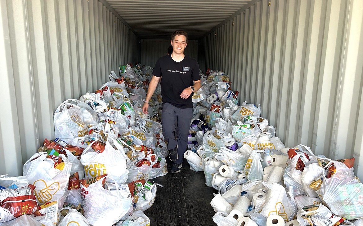 Taig Olsen walks among the bags of food that will be given away during Sunday's Day of Hope at the Kootenai County Fairgrounds.