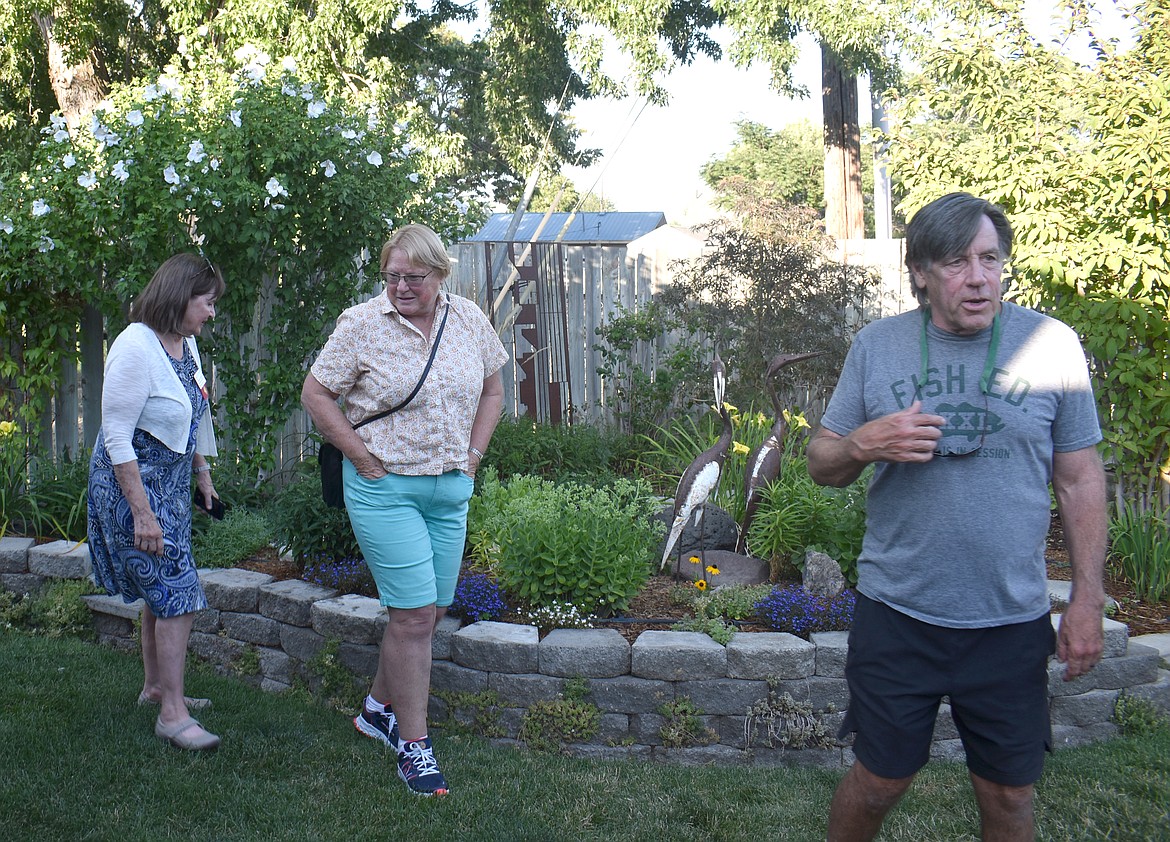 Attendees at the WSU Master Gardeners garden party Thursday look over hostess Barbara Guilland’s carefully-cultivated back yard.