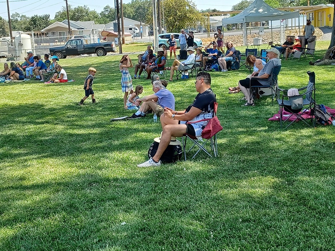 The audience takes refuge on shaded grass at the park while listening to performers Saturday. This year’s Folk and Food Festival is the first for the city and organizers are hoping to make it an annual event.