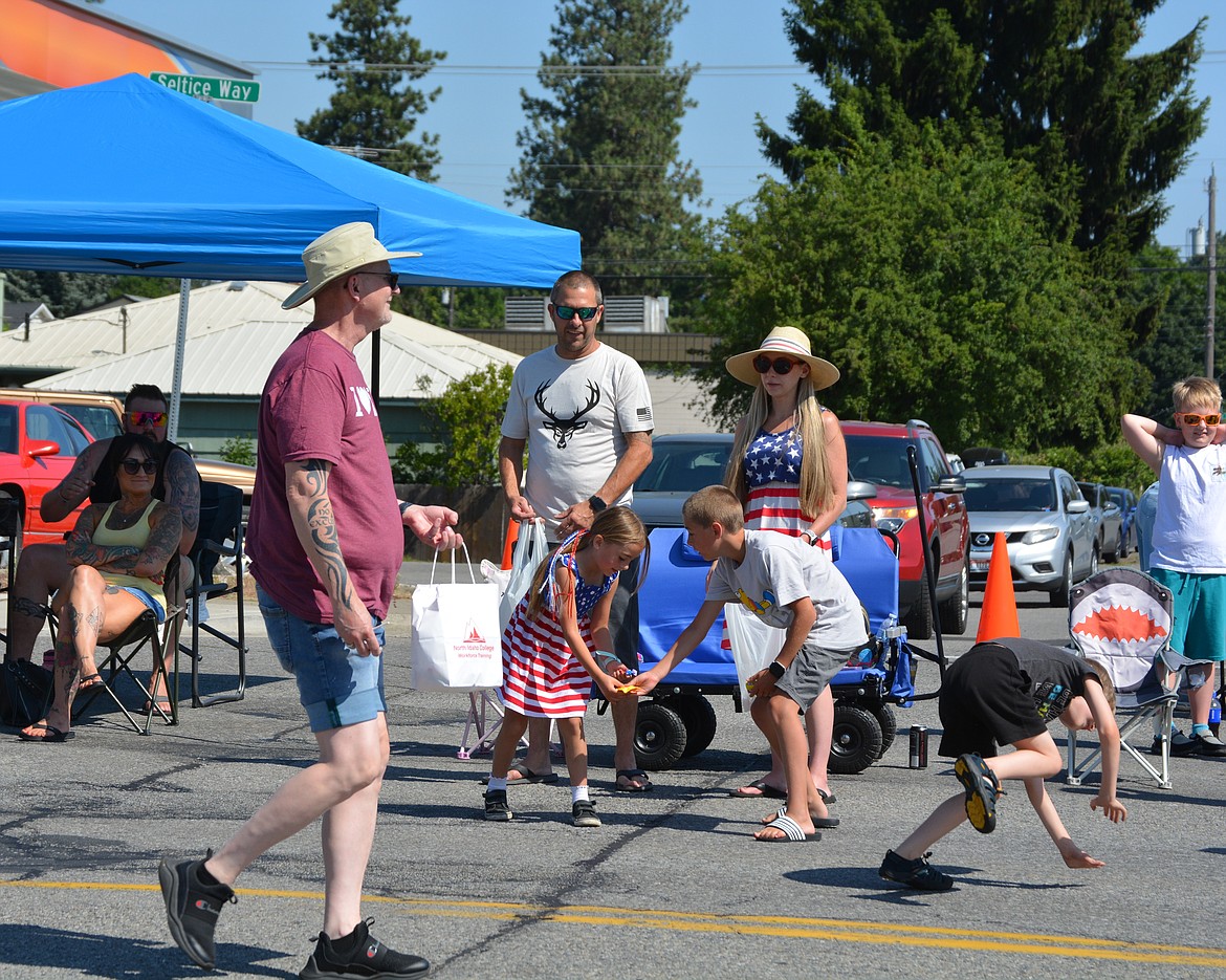 Siblings Breanna and Nicholas Edgar share their candy they've acquired as their parents, Jeremy and Abby Edgar watch the parade go by Saturday morning.