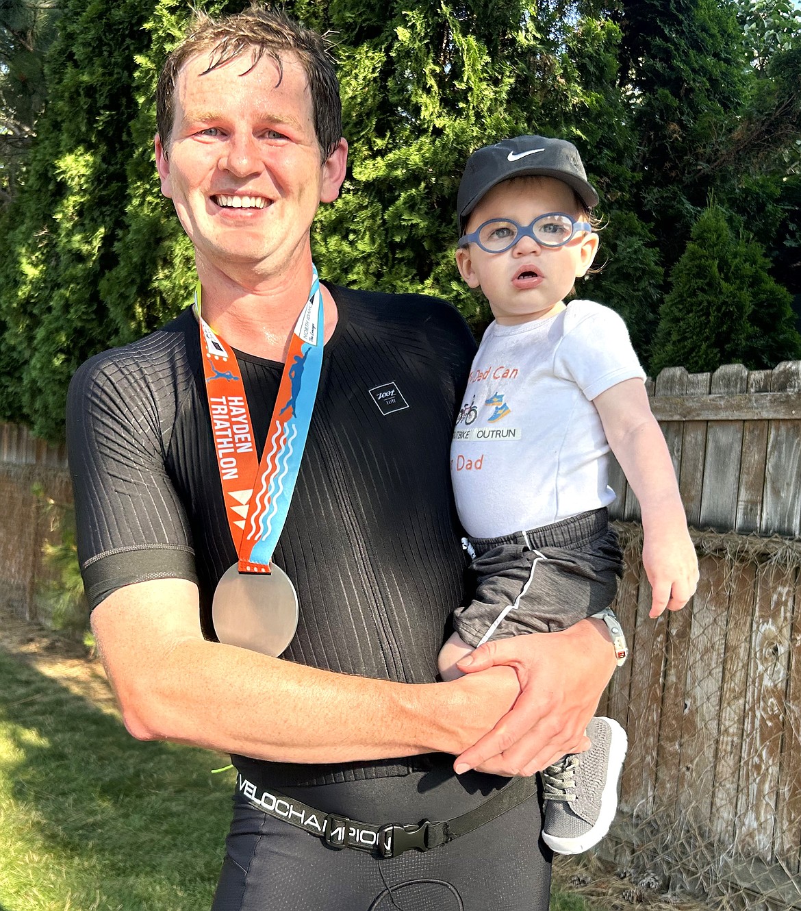 Danial Amann holds his son Easton after winning the Hayden Triathlon on Saturday.